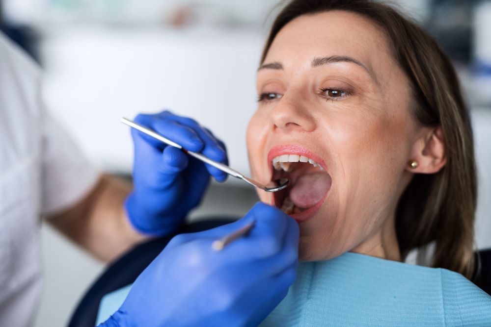 a woman has a dental check up in dentist surgery VAVTZ6Q 1