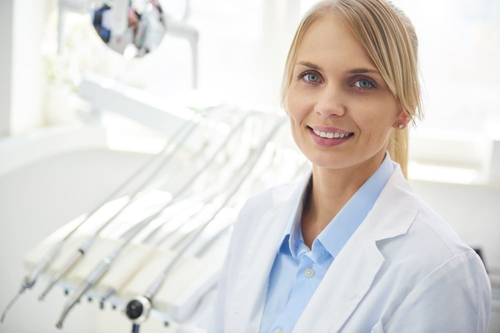 portrait-of-smiling-dentist-in-medical-uniform-in - 5WSQLTE