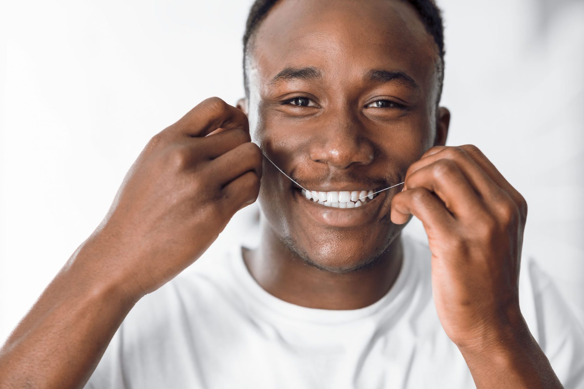 happy black man flossing teeth using dental floss 2022 12 16 07 46 34 utc 1 scaled